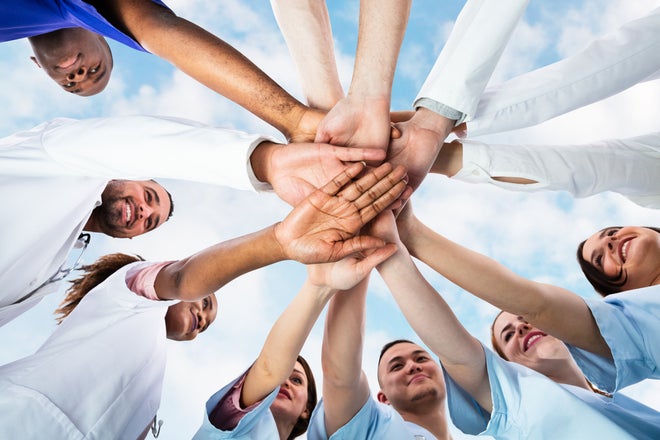 A group of people putting their hands together